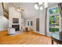 Bright living room featuring a fireplace, high ceilings, large windows, and hardwood floors at 4117 Olde Coach Rd, Durham, NC 27707