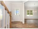 Bright foyer with hardwood flooring, a staircase and an entry door leading to a light-filled dining room at 454 Martins Mill Ct, Wendell, NC 27591