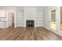 Spacious living room with hardwood floors, built-in bookshelves, a fireplace and an access to a covered porch at 454 Martins Mill Ct, Wendell, NC 27591
