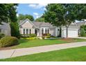 Charming single-story home with lush front lawn and colorful landscaping under mature shade trees at 621 Aylestone Dr, Cary, NC 27519