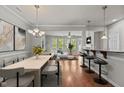 Open-concept living room with hardwood floors, natural light, and modern decor and bar area at 8323 Yaxley Hall Dr, Raleigh, NC 27616