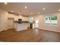 Open concept kitchen and living room with stainless appliances, granite counters and wood flooring at 912 Montague Ave, Durham, NC 27703