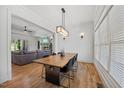 Elegant dining room with hardwood floors, modern light fixture, and large windows at 940 Rivers Edge Dr, Graham, NC 27253