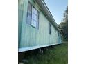 Exterior view of a single-story home with faded green siding and overgrown grass at 000 Us Route One, Cameron, NC 28326