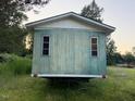 Back exterior view of a single-story home with faded green siding and overgrown grass at 000 Us Route One, Cameron, NC 28326
