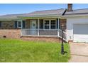 Close-up of a well-maintained brick home with a covered front porch and white trim, offering classic charm at 117 James Dr, Pine Level, NC 27568