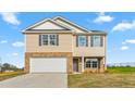 Two-story home featuring a brick and vinyl exterior with gray shutters and a concrete driveway at 119 Leven Dr, Gibsonville, NC 27249