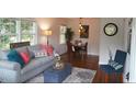 Cozy living room with hardwood floors, a comfortable sofa, and a view into the dining area at 1206 Downing Rd, Raleigh, NC 27610