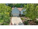 Inviting one-story home showcasing light blue siding, lush landscaping, and an attached garage at 125 Chimney Rise Dr, Cary, NC 27511