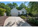 Attractive one-story home with light blue siding, mature trees, landscaping, and attached garage at 125 Chimney Rise Dr, Cary, NC 27511