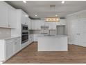 Bright kitchen with white cabinets, a kitchen island with quartz countertop, and stainless steel appliances at 1400 Gathering Park Cir # 203, Cary, NC 27519