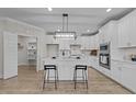 Well-lit kitchen features white cabinetry, quartz countertops, and an island with bar seating at 1400 Gathering Park Cir # 301, Cary, NC 27519