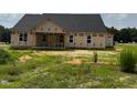 Back view of new construction home with black roof, framed windows, and covered porch at 171 Surles Landing Way, Benson, NC 27504