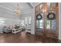 Elegant foyer with hardwood floors, a chandelier, and double doors leading to the living space at 2112 Colin Hill Ct, Wake Forest, NC 27587