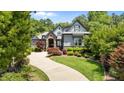 Beautiful home with a winding driveway, lush landscaping, and a manicured lawn at 2112 Colin Hill Ct, Wake Forest, NC 27587