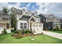Charming two-story home with a manicured lawn and a two-car garage in a suburban neighborhood at 237 Emory Bluffs Dr, Holly Springs, NC 27540