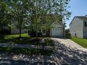 Inviting home featuring a driveway, well-maintained lawn, and mature trees for shade and curb appeal at 2826 Tulip Poplar Cir, Durham, NC 27704