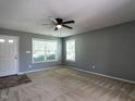 Inviting living room with carpet, gray walls, plenty of natural light and a contemporary ceiling fan at 2826 Tulip Poplar Cir, Durham, NC 27704