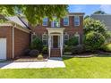 Inviting brick home with well-kept lawn and garden, leading to a welcoming front porch at 308 Sutton Glen Dr, Apex, NC 27523