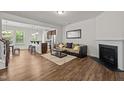Open-concept living room with wood floors, a fireplace, and views of the kitchen at 3810 Prince Noah Loop, Wake Forest, NC 27587