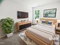 A serene main bedroom featuring soft lighting, a large window, and simple, elegant decor at 5356 Baywood Forest Dr, Knightdale, NC 27545