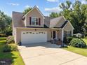 Inviting two-story home featuring an attached garage, landscaped yard, and traditional design at 545 Olivia Way, Selma, NC 27576