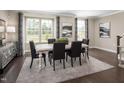 Elegant dining room featuring a large window, stylish furnishings, and a modern chandelier at 601 Rockwater Path, Durham, NC 27713