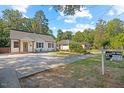 Charming white home with well-manicured lawn and 'For Sale' sign on a bright, sunny day at 606 E Club Blvd, Durham, NC 27704