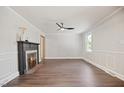 Bright living room with a decorative fireplace, crown molding, ceiling fan, and hardwood floors at 606 E Club Blvd, Durham, NC 27704
