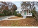 A cozy cottage with a welcoming front porch and a walkway leading to the entrance at 625 New Road Rd, Raleigh, NC 27608