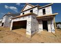 Under-construction home showing multiple units with a two-car garage, illustrating the building process and future potential at 69 Willow Cameron Way, Angier, NC 27501