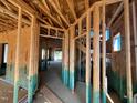 Exposed home framework showing wooden supports, an inside staircase, and interior spaces ready for customization at 69 Willow Cameron Way, Angier, NC 27501