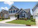 Charming two-story home with a stone accent, a two-car garage and manicured landscaping at 705 Churton Pl, Cary, NC 27518