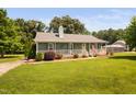 Beautiful ranch-style home boasts a well-manicured lawn, a front porch, and mature trees at 73 Richmond Dr, Archer Lodge, NC 27527