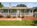 Charming home featuring a cozy front porch with flowers, a welcoming entrance, and a green lawn at 73 Richmond Dr, Archer Lodge, NC 27527