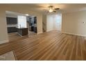 Open floor plan living room with wood floors connects to the kitchen with an island and staircase at 78 Mineral Springs Way, Benson, NC 27504