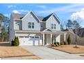 Two-story home boasts a two-car garage, covered porch, and manicured landscaping at 78 N Porcenna Ln, Clayton, NC 27527