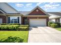 Charming brick home featuring a two-car garage, manicured lawn, and beautiful landscaping at 8007 Crookneck Dr, Angier, NC 27501
