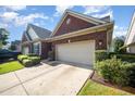 Charming brick home featuring a two-car garage, manicured lawn, and beautiful landscaping at 8007 Crookneck Dr, Angier, NC 27501