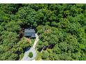 Expansive aerial view of a secluded house surrounded by a dense canopy of trees and well manicured grounds at 83 Calabria Ct, Clayton, NC 27527