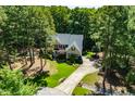 Stunning aerial view of a beautiful home nestled among mature trees with a long driveway at 83 Calabria Ct, Clayton, NC 27527