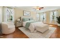 Bright bedroom with two windows, a plush bed, and a sitting area offers a serene retreat at 83 Calabria Ct, Clayton, NC 27527