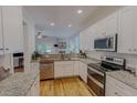 Modern kitchen with white cabinets, granite countertops, stainless steel appliances, and hardwood floors at 90 S Old Lantern Rd, Timberlake, NC 27583