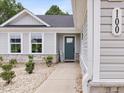 Inviting front entrance featuring a teal door, stone accents, and manicured landscaping at 100 Haddonfield Ct, Franklinton, NC 27525