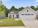 Charming single-story home with gray siding, a two-car garage, and a well-manicured lawn at 100 Haddonfield Ct, Franklinton, NC 27525
