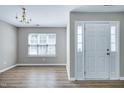 Inviting entryway with hardwood floors, a chandelier, a window, and a white door, creating a warm first impression at 103 Bermuda Green Dr, Durham, NC 27703