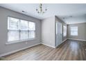 Charming entryway with hardwood floors, a chandelier, and natural light streaming in from the windows, offering a warm welcome at 103 Bermuda Green Dr, Durham, NC 27703