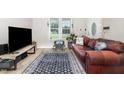 Bright living area featuring sleek wood floors, a large window, and comfortable seating at 11 Sherman Rd, Fuquay Varina, NC 27526