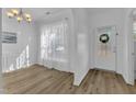 Bright dining room features wood-look floors, modern lighting, and a large window with natural light at 11309 Shadow Elms Ln, Raleigh, NC 27614