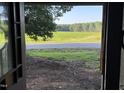 View from the doorway shows a picturesque scene of a field of green next to a road and tree line at 12670 School House Rd, Middlesex, NC 27557